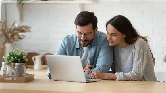 Couple using laptop together at home